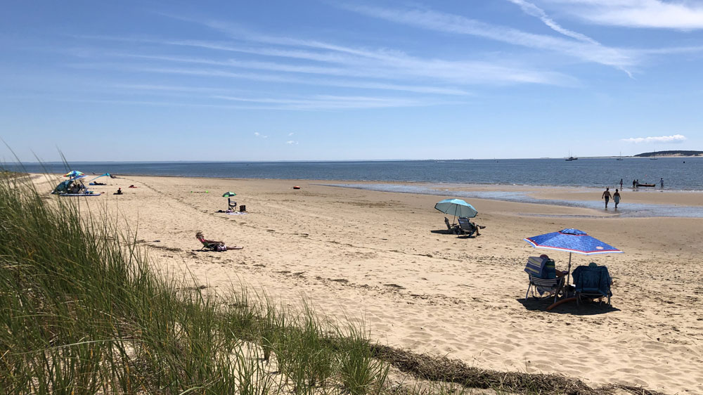 People relax on a sunny day at Indian Neck Beach in Wellfleet, Cape Cod.