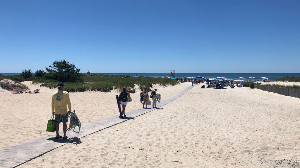 Umbrellas line the sand just past the boardwalk at Bank Street Beach in Harwich, Cape Cod.