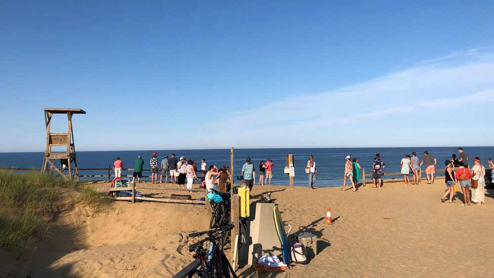Crowds take in the view at Cahoon Hollow Beach in Wellfleet, Cape Cod.