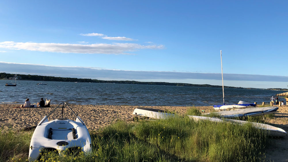 Boats line the shore at Jackknife Harbor Beach in Chatham, Cape Cod.