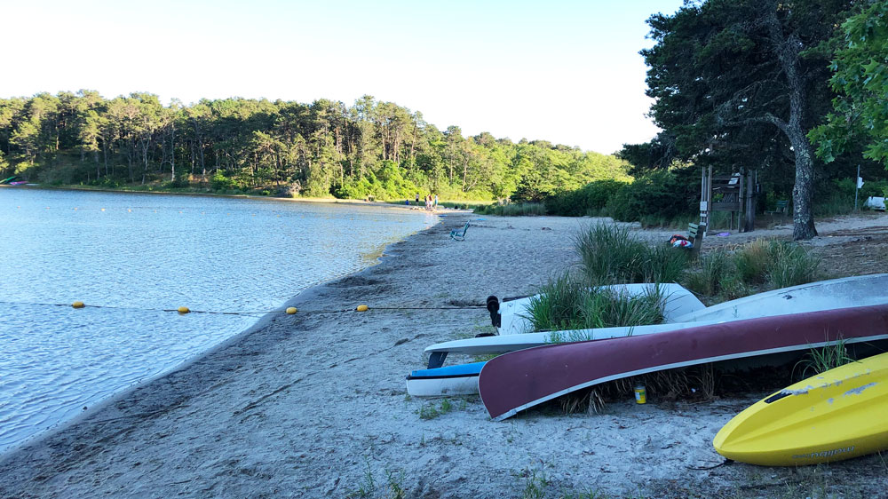 Canoes line the shore at Schoolhouse Pond Beach in Chatham, Cape Cod.