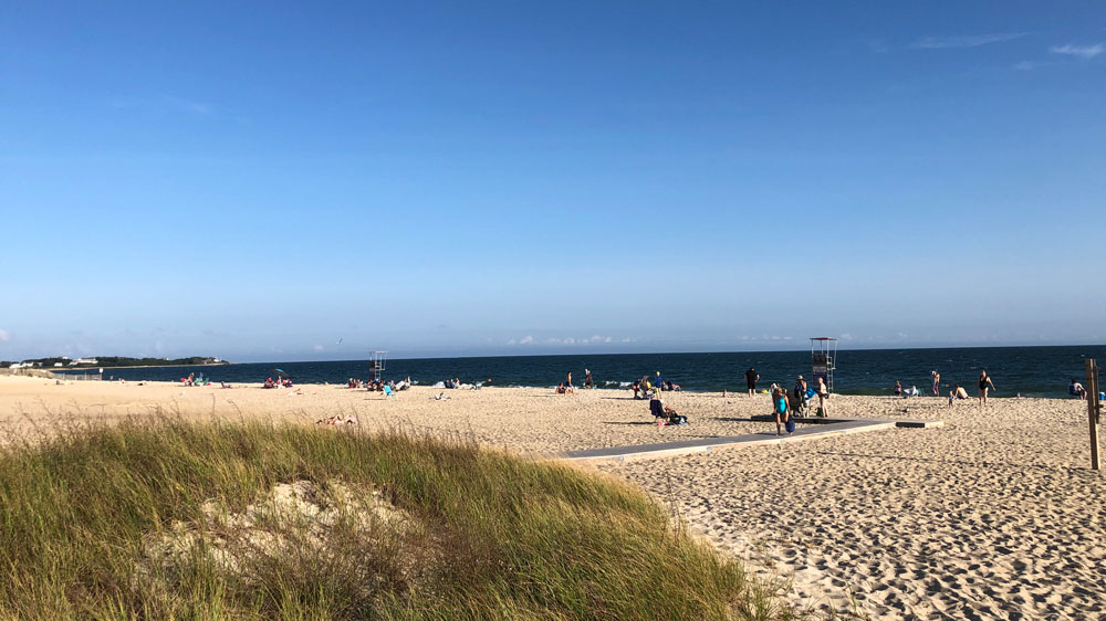 Beachgoers line the shore at Covell's Beach in Barnstable, Cape Cod.