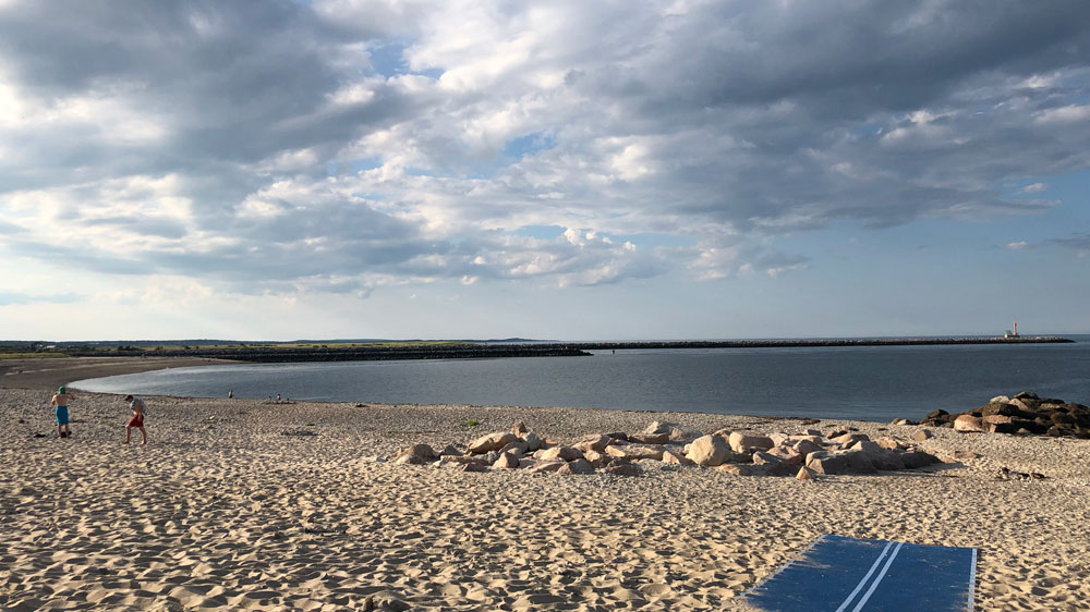 Kids walk along the rocky shore of First Beach in Sandwich, Cape Cod.