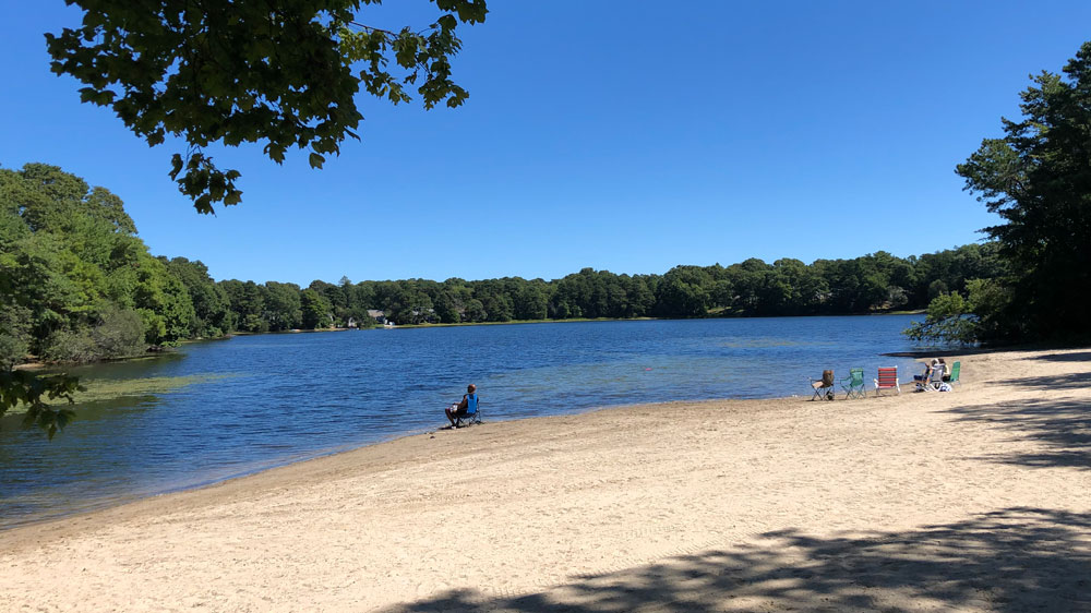 A man fishes on the shore of Picture Lake in Bourne, Cape Cod.