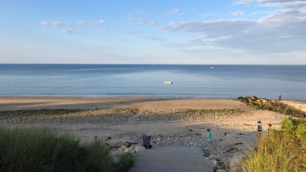 A dock floats in the calm water off Sagamore Beach in Bourne, Cape Cod.